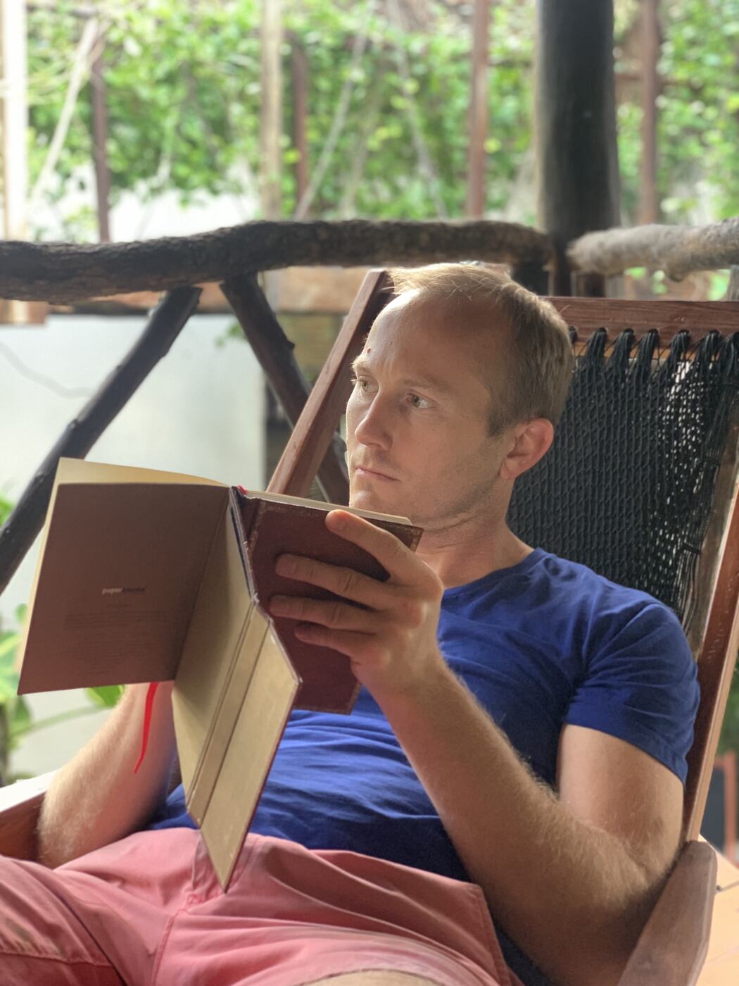 Clifton Smith reading in a hammock chair