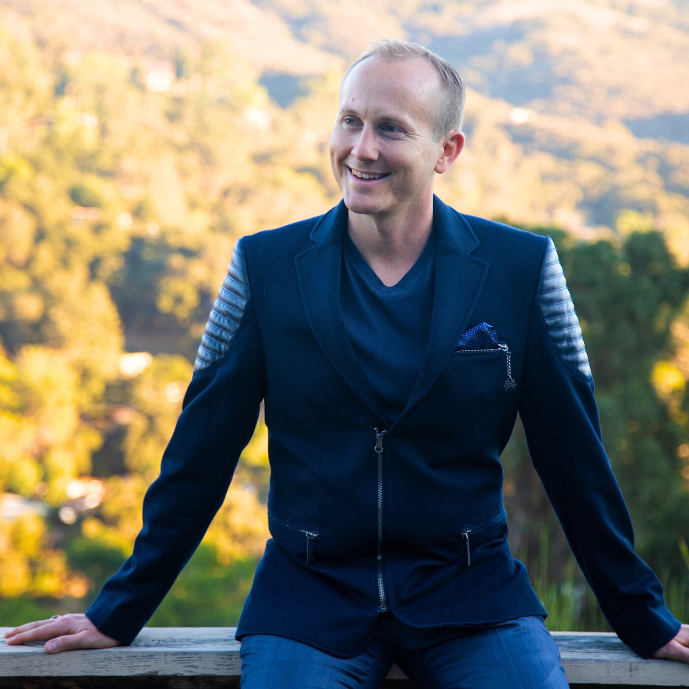 Clifton Smith in a navy jacket, seated outdoors
